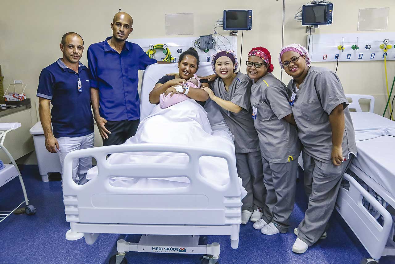 Junto com a equipe médica, os pais Valéria e Josimar apresentam Helena, o 500º bebê nascido na Maternidade Santa Ana